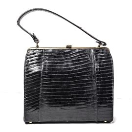 Alligator Skin Vintage Handbag: A vintage alligator skin handbag. This sleek black bag has brass details and sand colored leather interior with attached leather kiss clasp coin purse. This piece is unmarked.