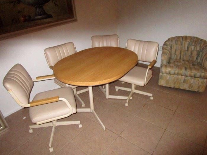 Informal dinning table and chairs. Chairs appear to be white leather