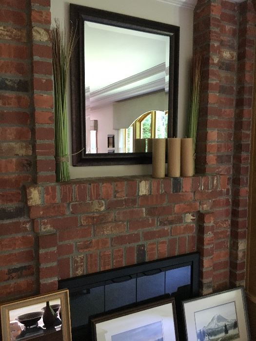 Framed beveled mirror shown with pillar candles 