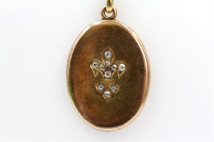 Vintage 14K Yellow Gold Old Mine Cut Diamond Locket Necklace: A vintage yellow gold oval pendant with fleur-de-lis design accented by diamonds to the front and an engraved “R” to the back on a thin yellow gold chain.