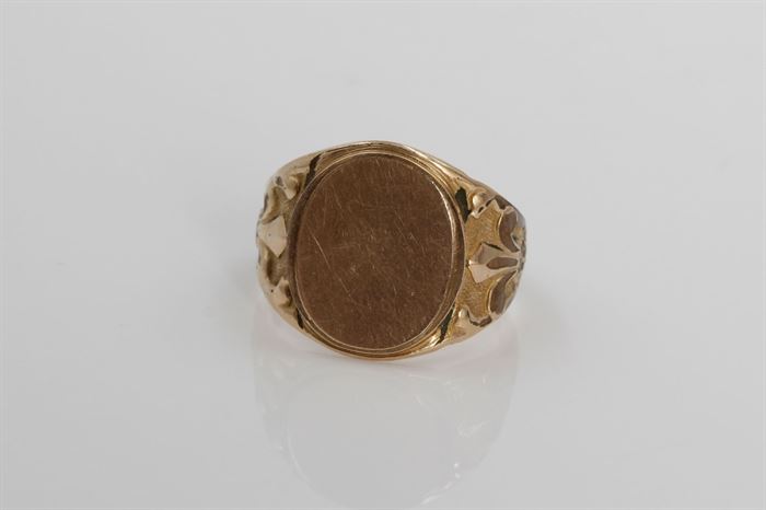 14K Yellow Gold Signet Ring: A yellow gold signet ring with fleur-de-lis carvings to the tapered shoulders.