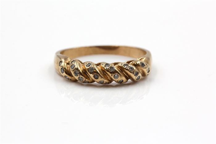 10K Yellow Gold Ring: A yellow gold ring with a twisted shank to the top and round cut glass accents to each coil.