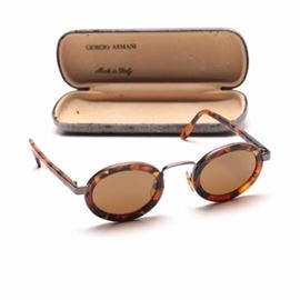 Vintage Armani Faux Tortoise Shell Sunglasses: A pair of vintage Georgio Armani faux tortoise shell sunglasses. These sunglasses feature a faux tortoise shell frame with nearly round light brown lenses. Georgio Armani is marked to the outside of each temple with additional branding to the inside of each earpiece. These sunglasses are made in Italy and have the serial number 631.