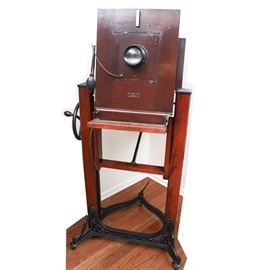 Eastman Kodak No. 8A Century Studio Camera: A Century studio view camera No. 8A, by the Folmer Schwing division of Eastman Kodak, dating to the first quarter of the 1900s. This beautiful mahogany studio camera is capable of using an 11×14 plate, as well as 8×10 and 5×7 inch plates. Camera has 43" bellows and 10×10 lens board. Camera features a Wollensak Velostigmat Series II F 4.5 N0. 224623 Focus 16 in lens. The Century Semi-Cetennial Stand No. 2A is included with this unique offering. to make a total studio outfit.