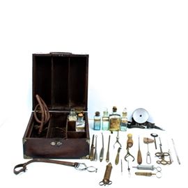 Antique Medical Kit: An antique medical tool kit. Featured is a dark stained solid wood hinged box with locking mechanism. Box opens to reveal a plethora of antique tools, and seven glass medicinal bottles.