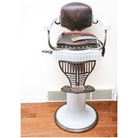 Circa 1920s Koken Child Size Barbers Chair: A vintage circa 1920s Koken child size barber chair. This piece features a white porcelain base, seat, and arms with leather back and seat cushions. The hydraulic chair has a cast metal foot rest with the maker’s name to the top and number 845 to underside.