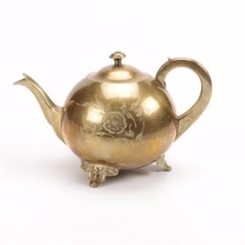 Indian Brass-Coated Teapot: An Indian brass-coated teapot. It has a round body with a handle and a spout with a floral etched pattern. Base metal is located to the interior. It has three brass tone feet. The underside is marked.