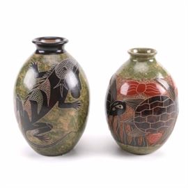 Pair of Animal Print Pottery Jars: A pair of animal print pottery jars. The larger jar is adorned with a lizard and marked “Aldo Bracamontes Nicaragua” to the bottom. The smaller jar is adorned with turtles and is unmarked.