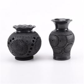 Pair of Black Clay Vases: A pair of black clay vases. Both have flower designs while one also has cutouts. Both are unmarked.