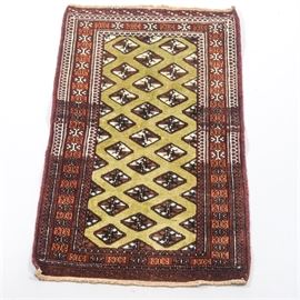 Hand Knotted Persian Turkoman Accent Rug: A hand knotted Persian Turkoman accent rug. This wool rug features diamond shaped guls in shades of brown and white on a lime colored field. The field is surrounded by a compound border in shades of rust, gold, indigo and white within a rust colored guard border, and the far ends have off-white fringe. Unmarked.