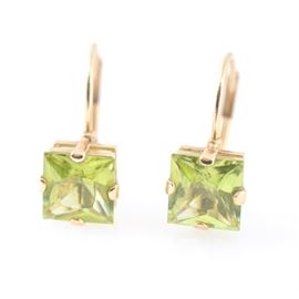14K Yellow Gold Natural Peridot Earrings: A pair of 14K yellow gold natural peridot earrings. The earrings feature single stones mounted on lever backs.
