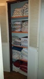a closet full of brand new sheets, curtains and more