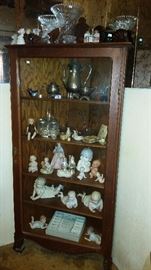 tiger oak corner curio cabinet filled with bisque piano babies and kewpies