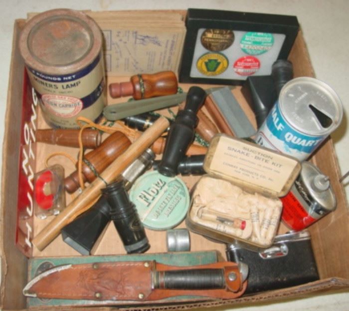 Box Of Hunting Items - Game Calls - Western Hunting Knife - NO HUNTING metal sign - License Buttons - Oil Can - Snake Bite Kit & More