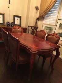 Italian marquetry dining table set.                               
table - L 63"xW 36"                                                                  4 chairs and 1 captain chair - carved solid wood, leather upholstery with nail head embellishment