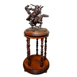 Sid Burns 1977 Bronze Sculpture "Eight Plus Two": A 1977 bronze sculpture titled Eight Plus Two by Sid Burns (1916 – 1979). A WWII veteran who formerly owned and operated a small shoe repair business in Laguna Beach, California, the Oklahoma-born self-taught artist began sculpting at the age of 50 when he returned to the Southwest. His subjects were often cowboys and his sculptures are best known for their portrayals of frantic moments frozen in time when both man and beast are in peril. This exemplary work of Burns showcases some of his finest artistry from its daring pose of rider and horse suspended in mid-air, to his finesse with regards to rendering the horses’ musculature, expressive movement and tack. The piece the captures the second of impact between a rodeo pick-up man and the rider he is attempting to rescue from getting thrown. The work is marked 1977, titled Eight Plus Two signed Sid Burns and numbered MB-15 to its base. The piece is presented on a round wooden swivel base