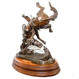 Sid Burns 1974 Bronze Sculpture "Spooked": A 1974 bronze sculpture titled Spooked by Sid Burns (1916 – 1979). Burns was a master sculptor who began his art career later in life at the age of 50 after relocating to Arizona. His Western-related subjects are often cowboys and horses portrayed in stunning detail throughout his meticulous eye and skilled hand. The work depicts a tossed rider and startled horse flying in mid-air after encountering a wild boar. The piece is inscribed “Master Bronze Spooked Sid Burns 1974” to its base and rests on a wooden base with a brass plaque which reads “Sid Burns Spooked 1974”.