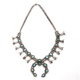 Sterling Silver Turquoise Squash Blossom Necklace: A sterling silver turquoise squash blossom necklace. The 22.50" hollow sterling beaded necklace features twenty oval cabochon stones and is finished with a hook and eye closure. The piece is unmarked, and tested as sterling when evaluated. Total approximate weight, inclusive of all materials, is 4.195 ozt.