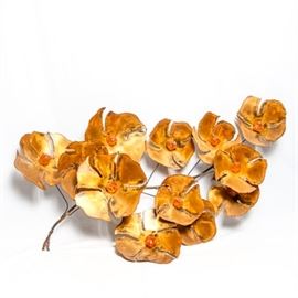 Mid Century Brutalist Metal Flower Wall Hanging: A mid century Brutalist metal flower wall hanging. The piece is comprised of twelve brass-tone sheet metal flowers with beaded edges connected by wire to their versos. An amber-toned resin stone accents the center of each flower. The piece is unsigned.