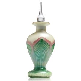 Louis Comfort Tiffany Favrile Perfume Bottle: An L C Tiffany favrile glass perfume bottle. This piece features a fluring lip on a short cylindrical neck and ovoid body in green glass washed with blush pink and iridescent green at the neck. This lower portion of the bottle has a mirrored finish over a straighted band of opalescent maize lappets edged in shaded green. Stoppered perfume bottle is marked “LC Tiffany” to underside.