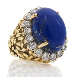 18K Yellow Gold Lapis Lazuli and 1.26 CTW Diamond Ring: An 18K yellow gold lapis lazuli and 1.26 ctw diamond ring. This cocktail ring features a lapis lazuli oval cabochon center stone surrounded by a halo of brilliant cut diamonds in a decorated yellow gold setting.