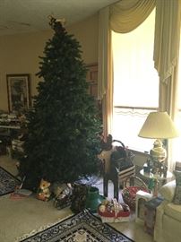 large pre-lit tree, lamps, small table, Christmas items