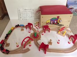 Wooden train set in wooden box with padded seat cushion. Additional pieces are in box and are not shown. This set is compatible with Thomas and Friends wooden track.