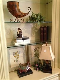 Framed art, small lamp, books, and decor