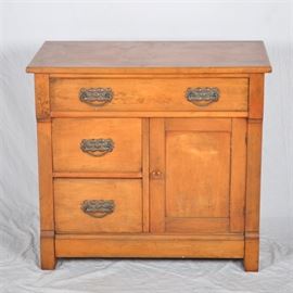 Late 19th Century Victorian Washstand: A late 19th century Victorian washstand. This washstand features a single drawer above two additional drawers to the left and a cabinet area to the right. Each of these drawers is constructed with knapp joints and has a swan neck pull with molded metal backplate. No maker’s marks are visible.
