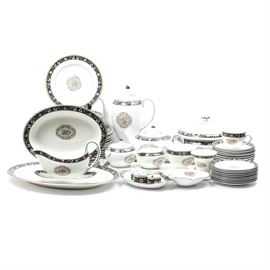 Wedgwood "Runnymede" China Set: A set of Wedgwood china in the Runnymede W4472 pattern. The pattern features colorful flowers, shells and scrolls to center and a black border. Maker’s mark to underside. Includes one shell dish, one gravy boat, ten salad plates, ten bread plates, fifteen dinner plates, one tureen, four napkin rings, one vegetable dish, a rectangular platter, one serving platter, eleven teacups and saucers, one teapot , one coffee pot, a creamer and a lidded sugar bowl, one small bud vase and a candy dish. Seventy-two pieces included.