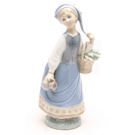 Lladró "Woman with Scarf " Figurine #5024: A Lladró figurine titled Woman with Scarf, #5024. The figurine depicts a woman in a blue and pink dress with a blue scarf. She is holding a basket of flowers on her arm and a pitcher in the other hand. The figurine was sculpted by Julio Fernandez in 1978 and later retired in 1985. The piece is marked with the Lladró stamp to underside and numbered 5024.