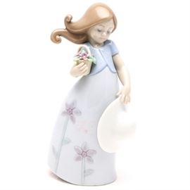 Lladró "Little Violet" Figurine #8043: A Lladró figurine titled Little Violet, #8043. The figure depicts a young girl with a lavender dress with flowers holding a basket of flowers and a white sun hat. The piece was sculpted by Jose Santaeulalia in 2004. The piece is marked to the underside with Lladró maker’s mark and model number.