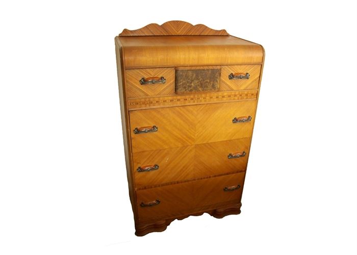 Vintage Art Deco Chest of Drawers: A vintage Art Deco chest of drawers. This unique chest is made of wood with a mixture of maple veneers and inlaid trims. It features four drawers with dovetail joinery, a scalloped back splash and base and combination gold colored plastic and aged bronze drawer pulls. This piece is a companion to 17CIN037, 17CIN038 and 17CIN040.