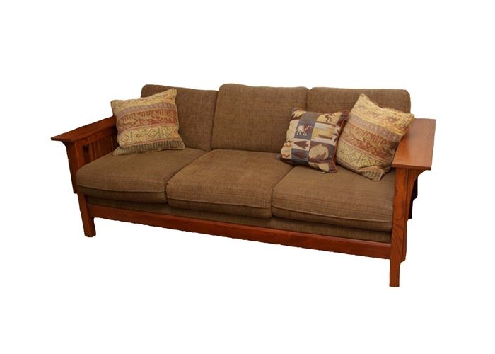 Mission Style Couch by Bassett: A Bassett mission style couch. This couch frame is made of oak and stained in a warm brown finish. It features mission style arms with detachable seat and back cushions. The cushions are upholstered in a primarily brown chenille fabric with touches of gold, rust and blue. Three southwestern inspired coordinating accent pillows are also included.