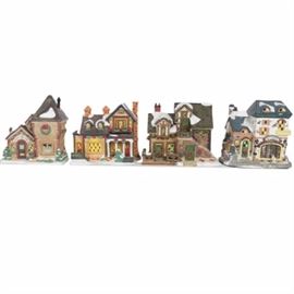 Collection of "Santa's Workbench Collection" Illuminated Houses: A set of four illuminated houses from Santa’s Workbench Collection, circa 2002. Includes three from the Towne Series featuring Crumbs Cake Shoppe, Nym’s Nook, and Laurel Hill House. Also included is Sweet Stuff Bakery from the Interior View Series. Each is made of porcelain and features intricate hand-painted details with a light to the interior.