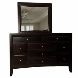 Contemporary Dark Espresso Dresser with Mirror: A contemporary dresser with mirror. The dresser with mirror is made of hardwood that features a dark espresso finish. The dresser features nine drawers for ample storage and is adorned with satin nickel knobs. The piece includes a square mirror that attaches to the dresser with brackets. This piece coordinates with items 17CLT086-043 and 17CLT086-044.