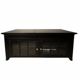 Black Entertainment Cabinet: A contemporary style entertainment cabinet. The stand is made of engineered wood and is black in color. The piece features two cabinet doors to the front. The doors are glass paned and adorned with brushed nickel hardware.