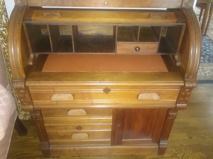 Pull out leather desk top under cylinder...sectioned interior..small drawer