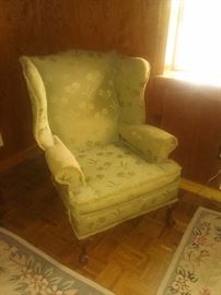 Antique Queen Anne wing back chair with original fabric and manufacturer's label on bottom.. wood carved ball and claw feet