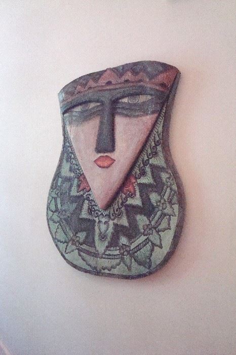 One of a pair of wooden hand carved and decorated wall hangings.