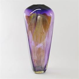 Signed Amethyst and Umber Art Glass Vase: A signed amethyst art glass vase. by K. Richard. This elongated vase features a flattened tapered design, with gold tone and umber detailing. Base is signed “K. Richard.”