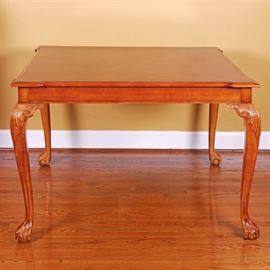Chippendale Style Square Dining Table: A Chippendale style dining table with a mahogany finish. This table features a square top with bookmatched veneers. It is supported by cabriole legs with carved acanthus leaves to the knees and ball-and-claw feet. The piece is marked “Made in Taiwan R.O.C. 80880100” to the underside.