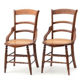 Victorian Eastlake Side Chairs: A pair of Victorian Eastlake side chairs. These chairs have an incised crest rail with ladder backs, side supports and circular caned seats. They rest on turned legs and stretchers.
