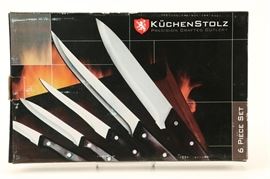 KüchenStolz Knife Set: A set of KüchenStolz knife set. This six piece set features five knives in varying sizes and a sharpening tool. The knives have stainless blades, were made in China and are marked “KüchenStolz precision crafted cutlery.”
