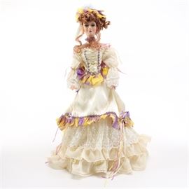 Premiere Edition Diamond Liz Doll: A Premiere Collection Diamond Liz doll. This doll designed by artist Kathleen Hill, features a porcelain face, bodice, arms, and legs. The doll features sewn fabric clothing and a headdress. The back of the doll’s neck is marked, “Kathleen Hill, AEL 2002.” Included with the doll is a Certificate of Authenticity.