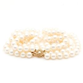 14K Yellow Gold Triple Strand Pearl Necklace: A 14K yellow gold triple strand pearl necklace. This necklace features cultured fresh water pearls with a triple strand and is accompanied by an ornate open design to the box tab closure.