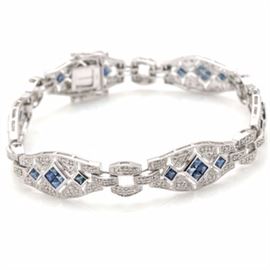 14K White Gold Sapphire and Diamond Link Bracelet: A 14K white gold sapphire and 0.73 ctw diamond link bracelet. This bracelet features bezel set square faceted sapphires in a repeating link pattern that are surrounded on each link by round brilliant cut diamonds and a milgrain decorative detail edge.