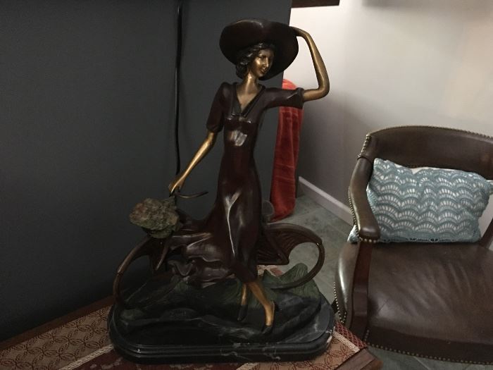 Beautiful bronze Depicting girl holding hat ready to get on her bicycle