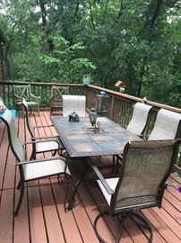 Seven piece  patio Metal dining set,  six  arm chairs, two that Rock and swivel table top has tile inserts.