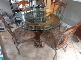 Lovely breakfast table with extra heavy beveled glass top and four heavy iron/wood side chairs.